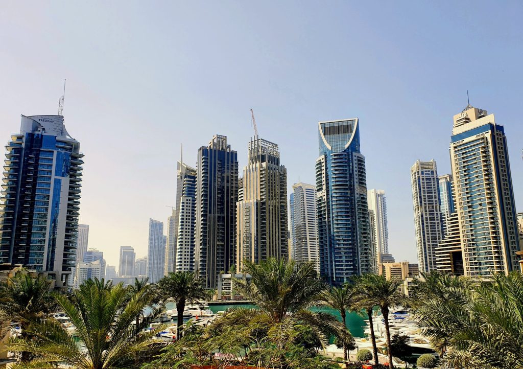 Deciphering the May Dip in Dubai’s Shifting Property Market: A vibrant view of Dubai's skyline featuring modern skyscrapers and palm trees during the day.