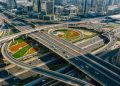 Aerial view of a bustling urban highway interchange amidst skyscrapers and modern architecture. Credit: Mikhail Nilov.